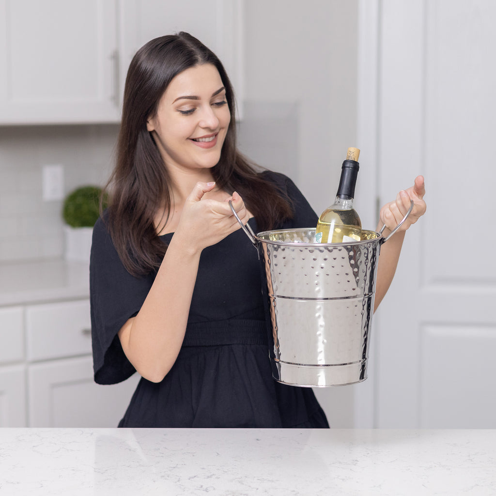 Wine or champagne bucket made of stainless steel metal to use in your kitchen, dining room, bar, or patio.  Hammered exterior and easy to clean mirrored glossy finish.