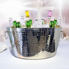 Stainless steel ice bucket that is very reflective and includes a hammered exterior.  The bucket includes to handles with bottles chilled by ice inside.